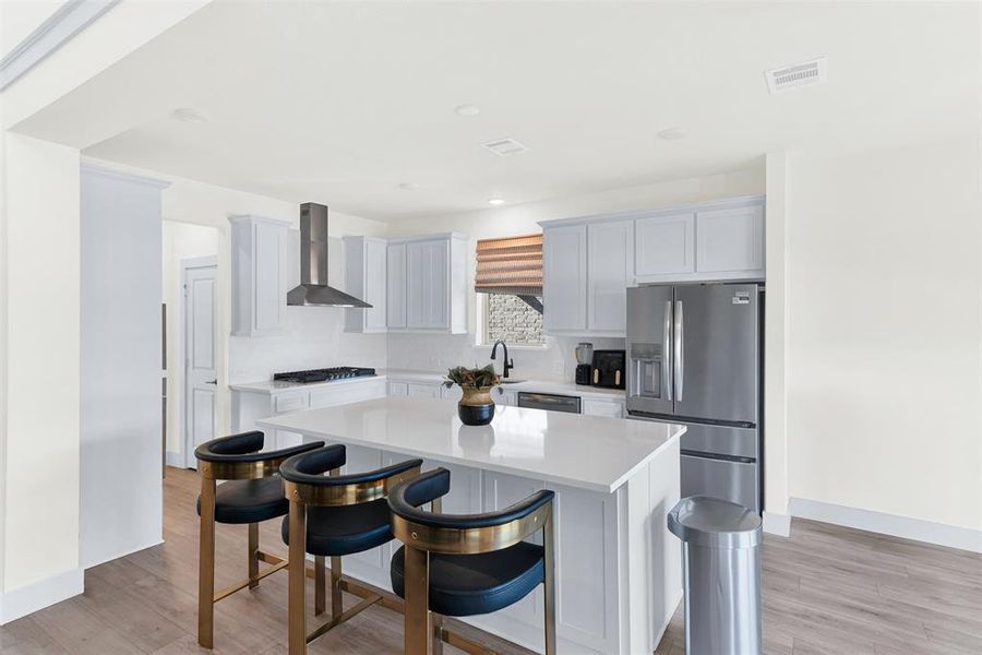 Kitchen featuring appliances with stainless steel finishes, a kitchen breakfast bar, light wood-style flooring, a center island, and recessed lighting Kitchen featuring appliances with stainless steel finishes, a kitchen breakfast bar, light wood-style flooring, a center island, and recessed lighting