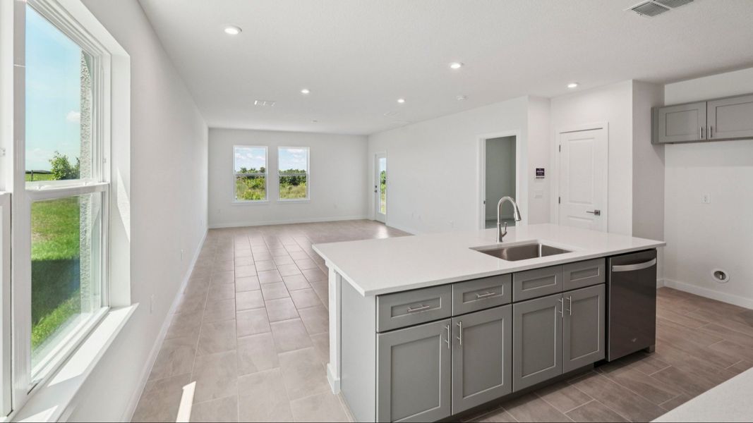 Kitchen Island and Living Area of the Jupiter in Hamilton Bluff located in Haines City, FL.
