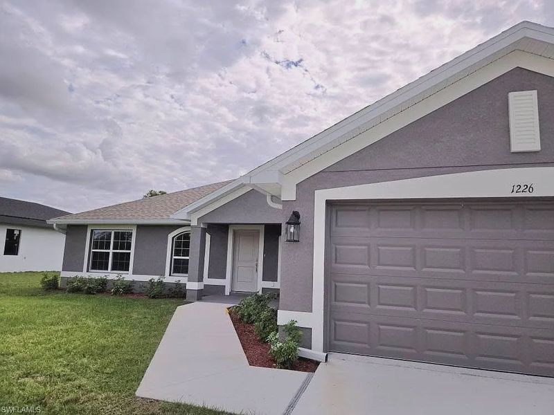 Front exterior of a new home in Lehigh Acres, Lehigh Acres, FL, highlighting curb appeal (Image 1).