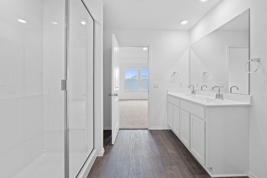 Full bath featuring double vanity, dark wood-style floors, a shower stall, and recessed lighting Full bath featuring double vanity, dark wood-style floors, a shower stall, and recessed lighting