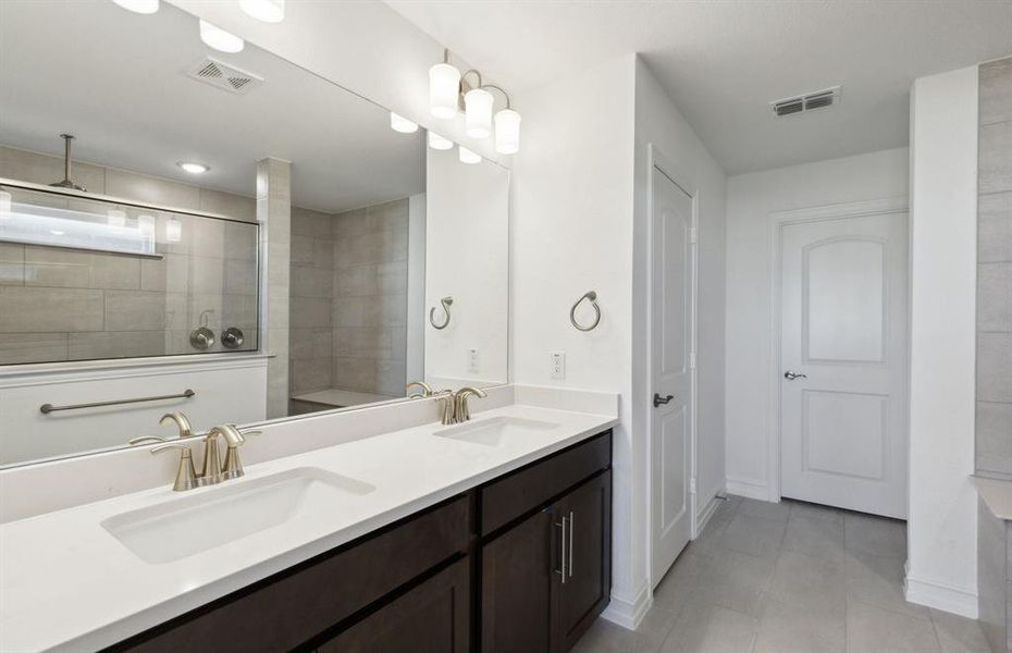 Private owner's bathroom with dual vanity and oversized shower*real home pictured