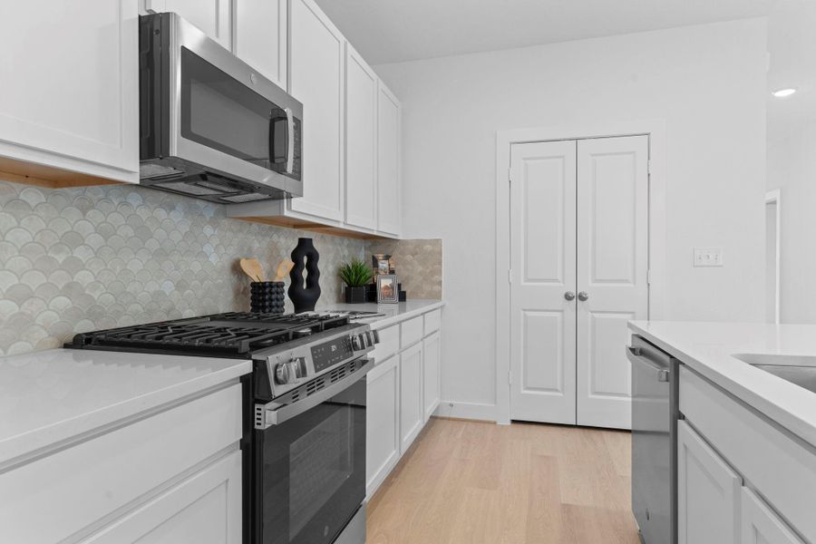A closer look shows off the generous pantry space and thoughtful layout that keeps everything within easy reach—ideal for busy mornings and family dinners alike.  Wonderful stainless-steel 5 burner gas range with a built-in stainless steel microwave oven and so much more.