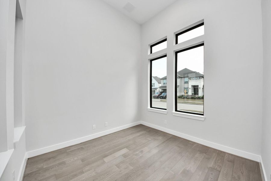 Wood floors in your study with tall vaulted ceilings.