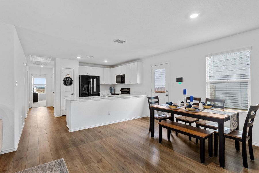 Contemporary kitchen and dining area featuring wood-finish flooring