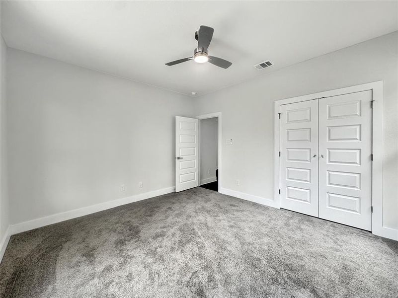 Unfurnished bedroom featuring carpet floors, ceiling fan, and a closet Unfurnished bedroom featuring carpet floors, ceiling fan, and a closet
