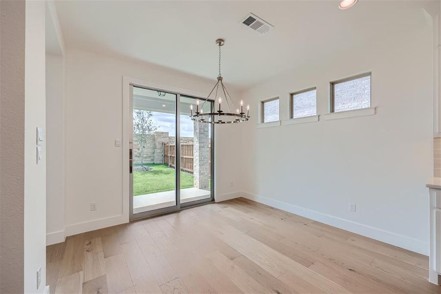 Unfurnished dining area with a notable chandelier and light hardwood / wood-style floors