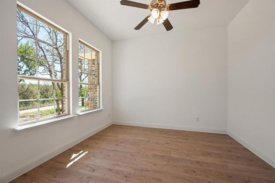 Spare room with hardwood / wood-style floors and ceiling fan