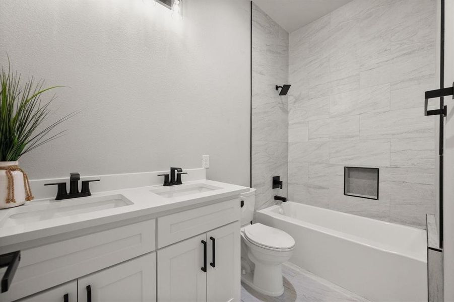 Full bathroom featuring double vanity and shower / bathtub combination Full bathroom featuring double vanity and shower / bathtub combination