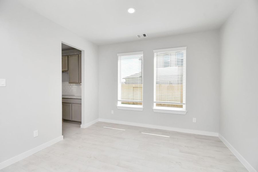 Make memories gathered around the table with your family and friends! This spacious dining room features elegant flooring, custom paint, and adjacent to family room and kitchen for open concept feel. Sample photo of completed home with similar floor plan. Actual colors and selections may vary.