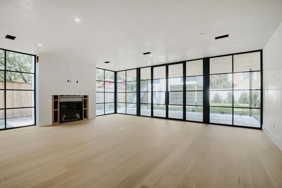 Floor-to-ceiling windows and a fireplace define this contemporary living space.