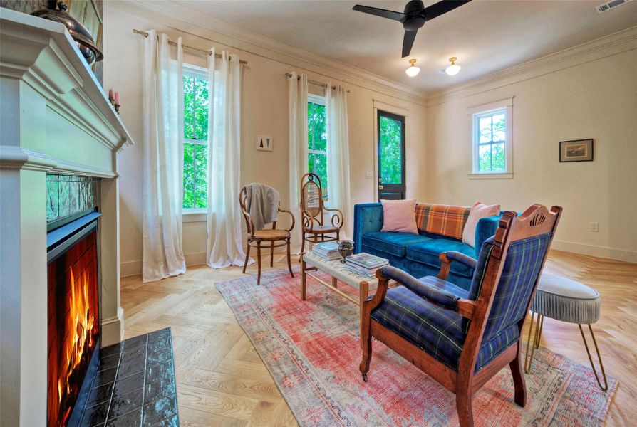 A welcoming living area showcases a cozy fireplace and rich hardwood flooring, complemented by ample natural light.