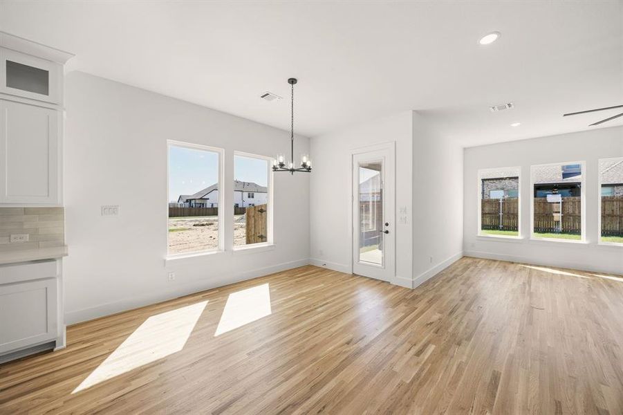 Unfurnished dining area featuring a chandelier and light wood finished floors