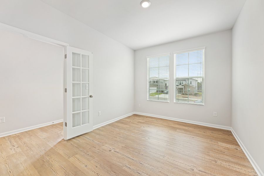 A room with a wood floor and a white door.