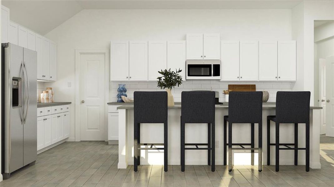 Kitchen featuring backsplash, stainless steel appliances, dark countertops, and lofted ceiling Kitchen featuring backsplash, stainless steel appliances, dark countertops, and lofted ceiling