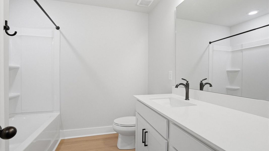 Top-notch bathroom with current fixtures, tasteful materials, and elevated charm by DRB Homes Top-notch bathroom with current fixtures, tasteful materials, and elevated charm by DRB Homes