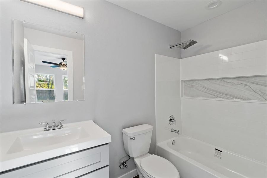 Full bathroom with vanity, toilet, shower / bathing tub combination, and ceiling fan