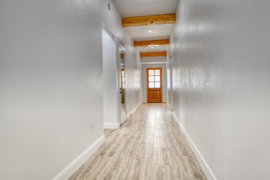 Hall featuring beam ceiling and light hardwood / wood-style floors