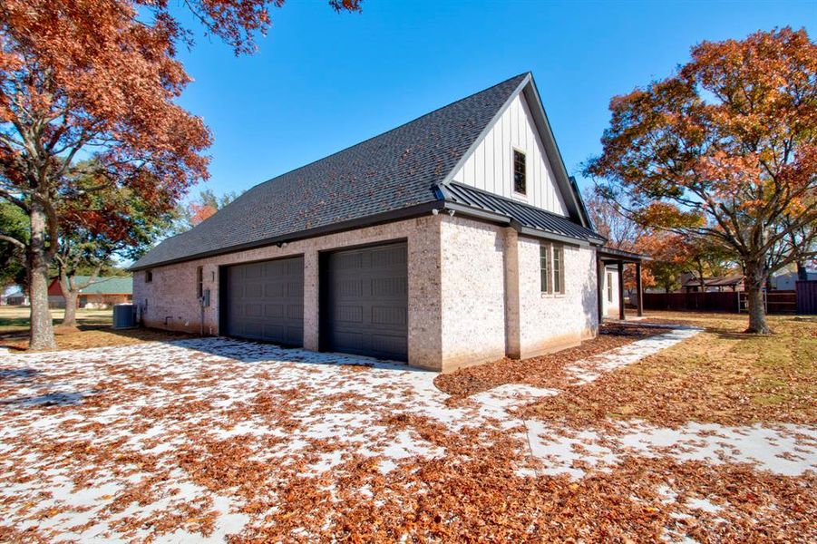 View of side of home with a garage and central air condition unit