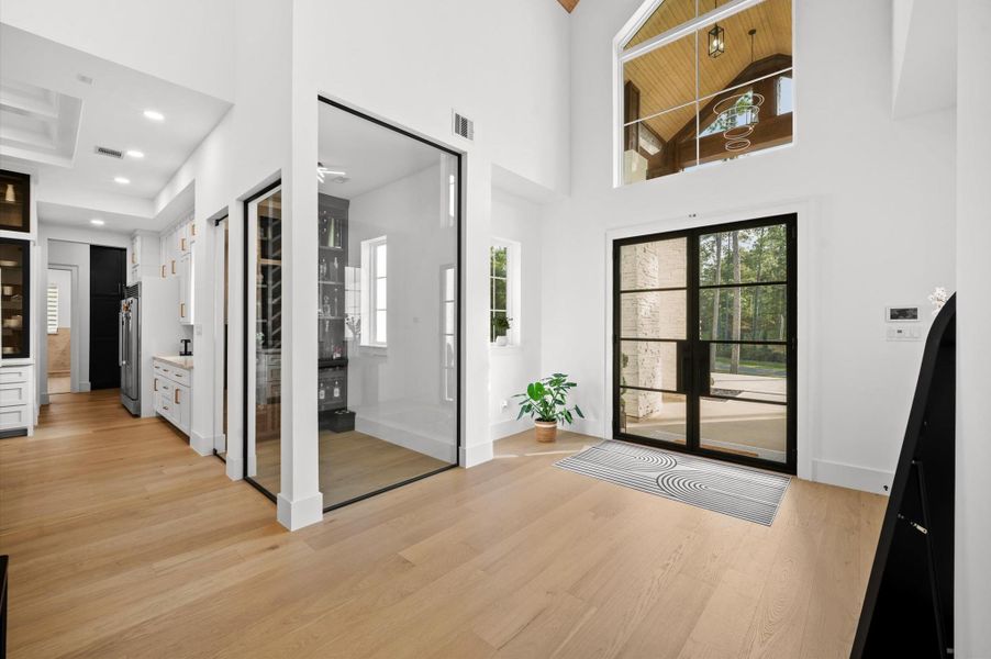 Glass-enclosed wine room creates a striking architectural feature while showcasing your collection.