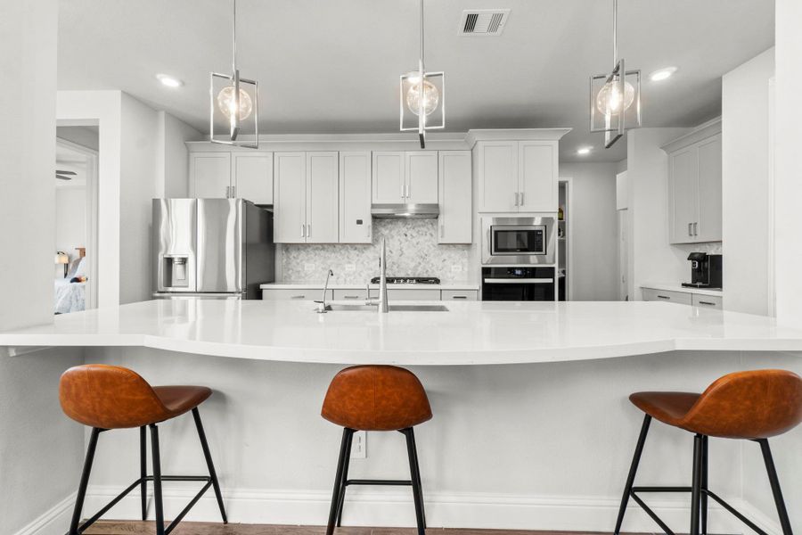 Plenty of countertop space on this Island, a 30" cooktop for the Chef of the family and 42" upper cabinets.