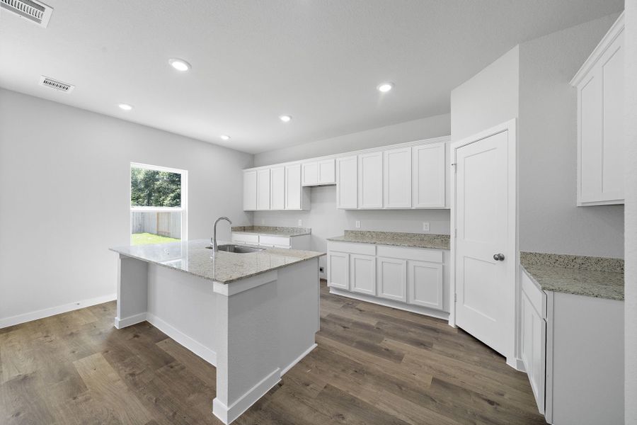 A kitchen with white cabinets.