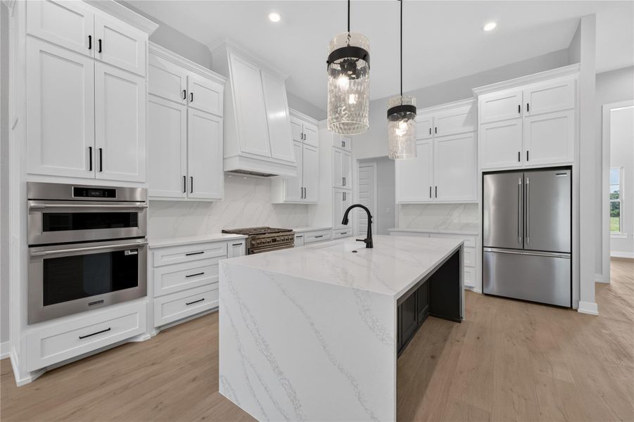 Crisp white cabinetry pairs perfectly with a waterfall island and sleek built-in appliances.