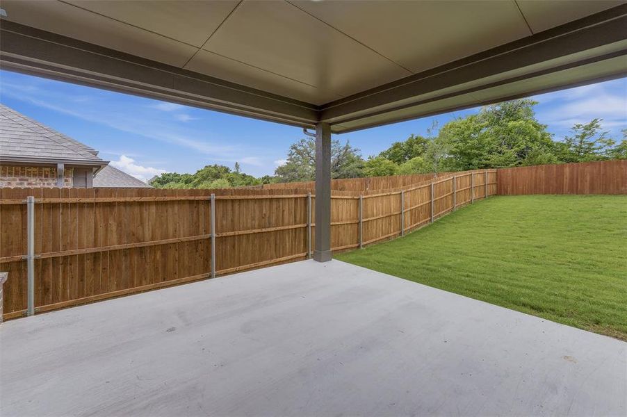 Covered patio featuring a concrete surface and a wood privacy fence