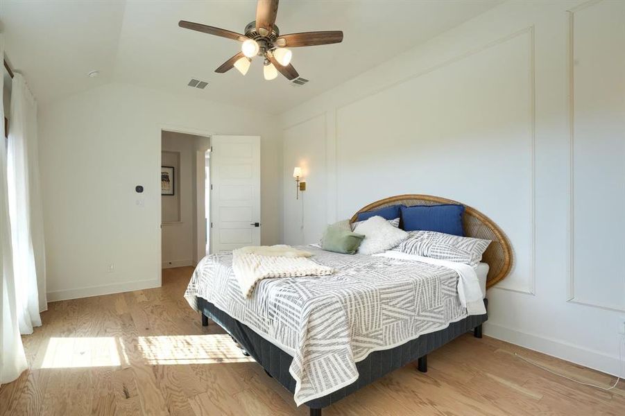 Bedroom featuring vaulted ceiling, light wood-type flooring, and ceiling fan