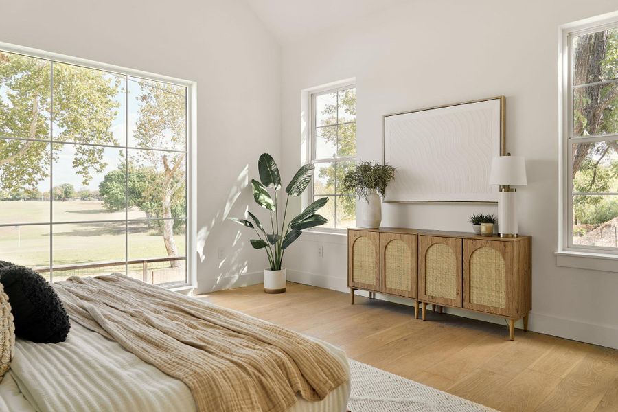 Bedroom with light wood-style flooring and lofted ceiling Bedroom with light wood-style flooring and lofted ceiling