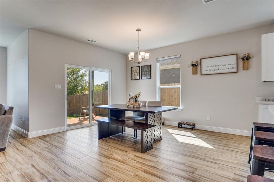Dining area with light wood-style flooring and a chandelier