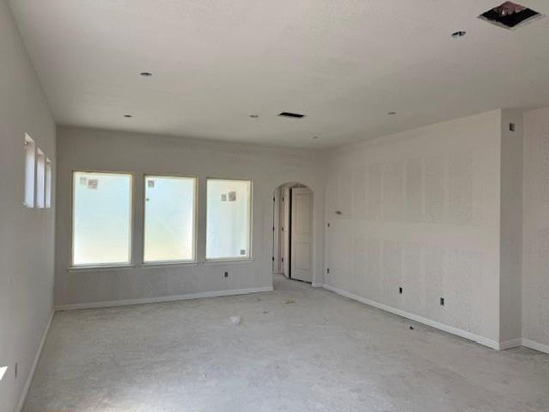 A spacious, newly constructed room awaits finishing touches with ample natural light.