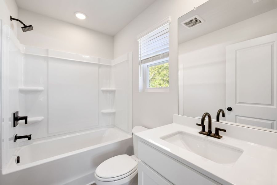 A bathroom with a tub sink and toilet. A bathroom with a tub sink and toilet.