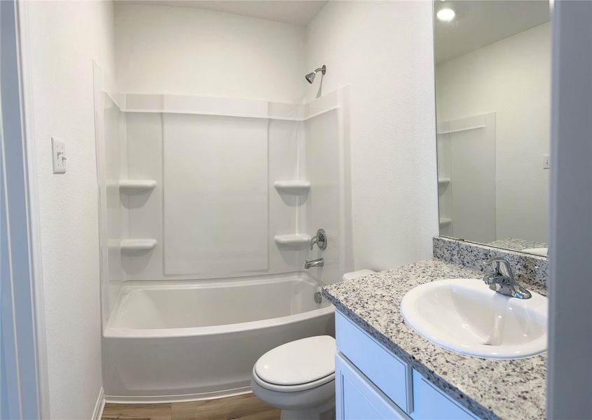 Primary bathroom includes granite counters, designer white cabinetry and luxury vinyl plank flooring. Primary bathroom includes granite counters, designer white cabinetry and luxury vinyl plank flooring.