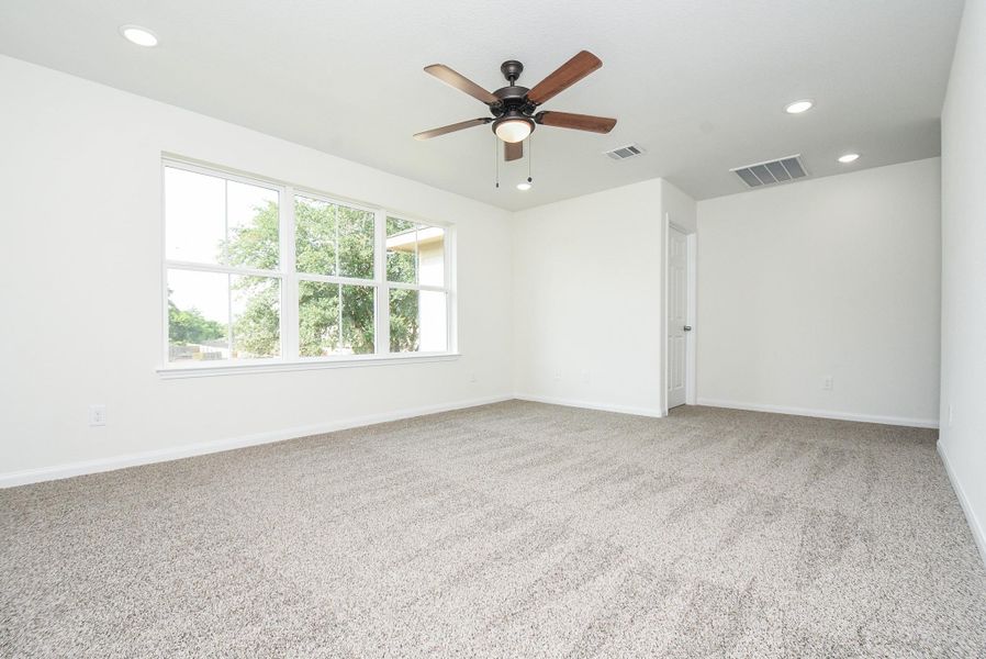 This is a bright, spacious room with large windows, neutral carpeting, and a ceiling fan. It appears freshly painted and ready for move-in. This is a bright, spacious room with large windows, neutral carpeting, and a ceiling fan. It appears freshly painted and ready for move-in.