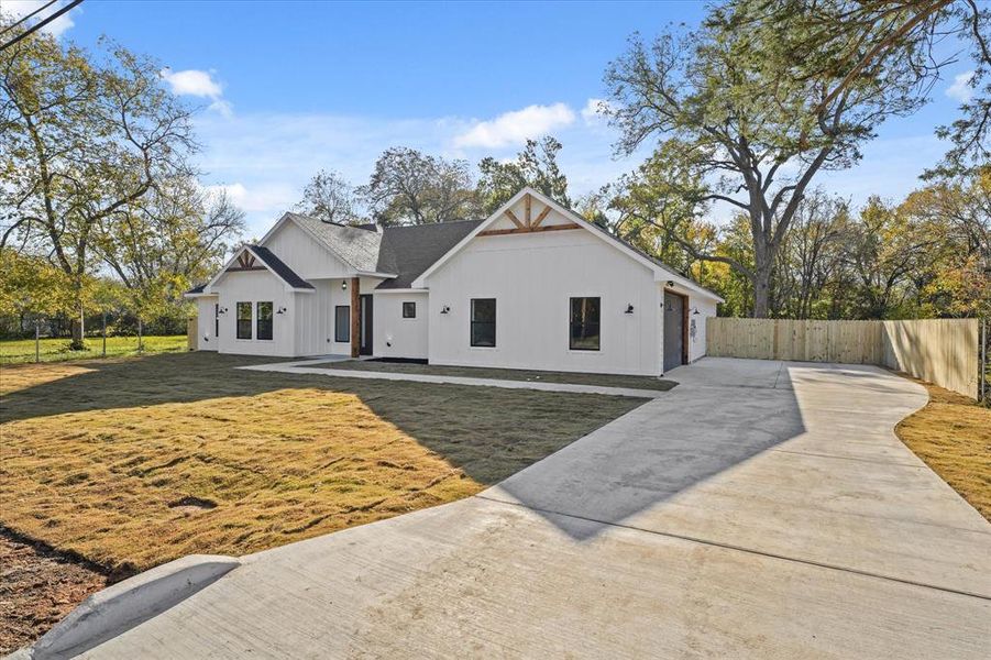 View of front of house with a garage and a front lawn