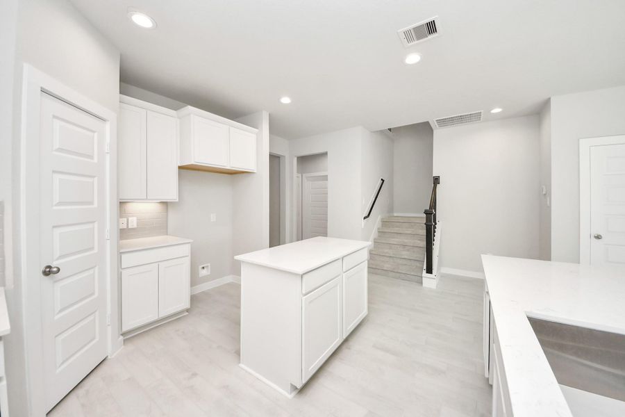 Discover another perspective of this stunning kitchen, generously appointed with an abundance of counter space. Sample photo of completed home with similar floor plan. Actual colors and selections may vary.