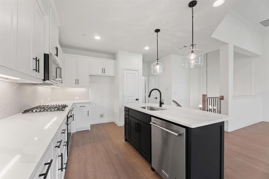 Kitchen with white cabinets, light wood-type flooring, stainless steel appliances, a center island with sink, and recessed lighting Kitchen with white cabinets, light wood-type flooring, stainless steel appliances, a center island with sink, and recessed lighting