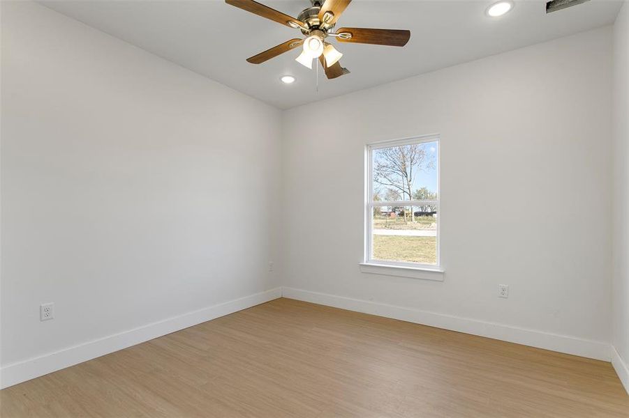 Spare room featuring light wood-type flooring and ceiling fan