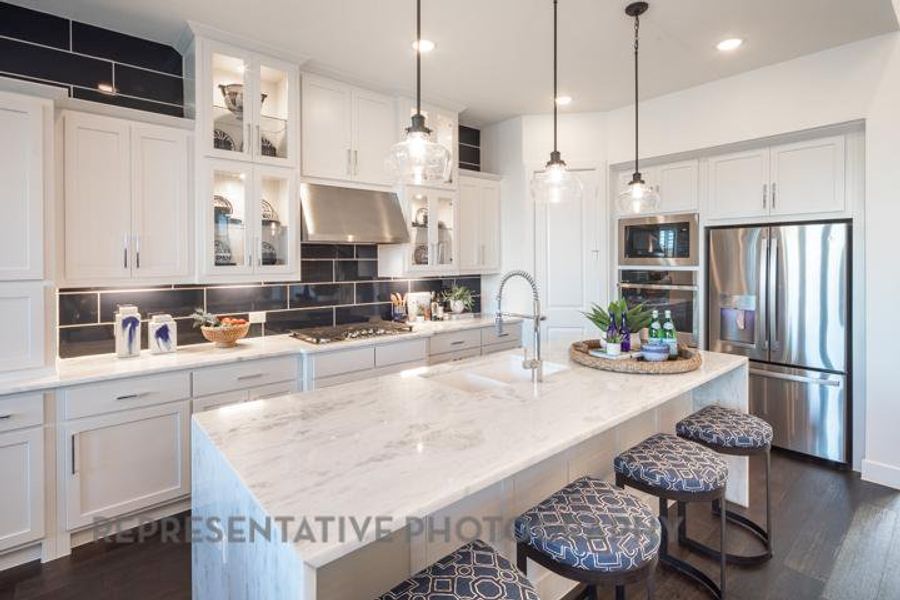 Kitchen with appliances with stainless steel finishes, dark wood-type flooring, white cabinetry, a breakfast bar, and recessed lighting Kitchen with appliances with stainless steel finishes, dark wood-type flooring, white cabinetry, a breakfast bar, and recessed lighting