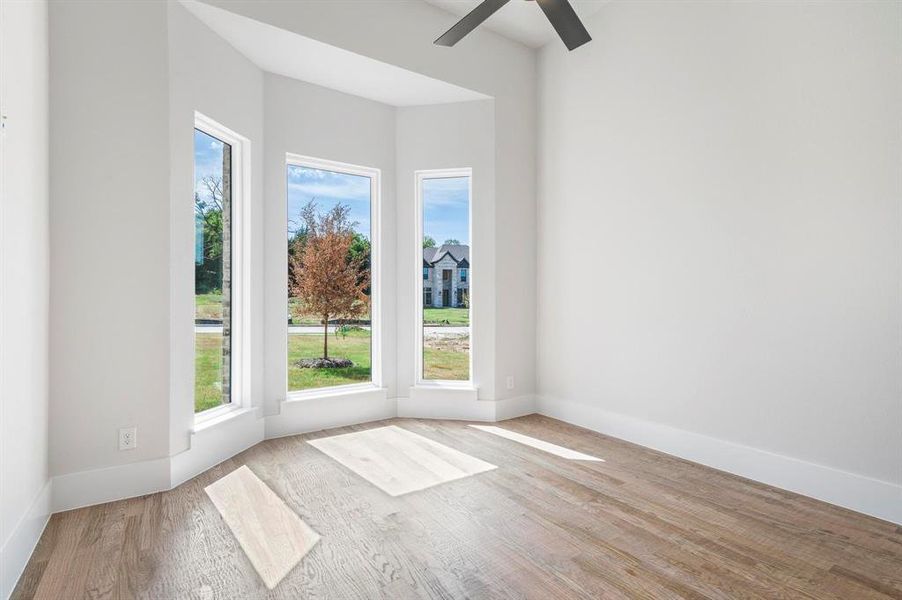 Empty room featuring light hardwood / wood-style flooring and ceiling fan