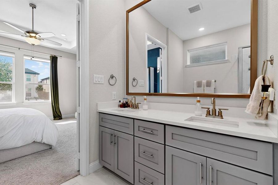 Ensuite bathroom with double vanity, healthy amount of natural light, ceiling fan, recessed lighting, and a stall shower Ensuite bathroom with double vanity, healthy amount of natural light, ceiling fan, recessed lighting, and a stall shower