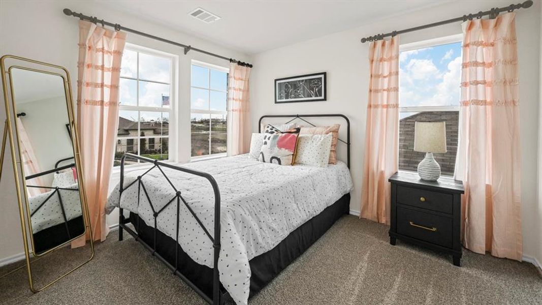 Bedroom featuring multiple windows and dark colored carpet
