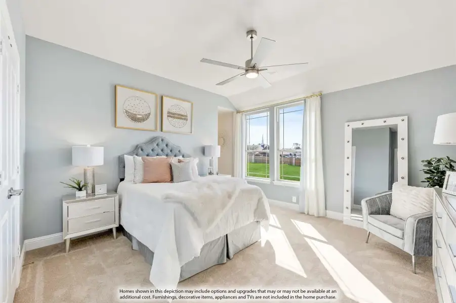 Bedroom with vaulted ceiling, ceiling fan, carpet floors, and large windows with backyard view