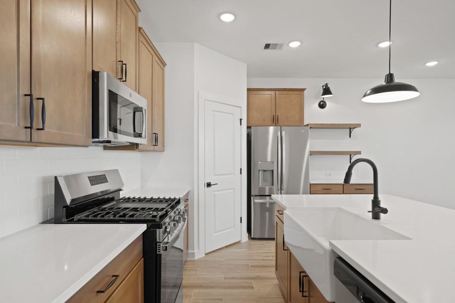 Stylish kitchen with chestnut brown cabinets and quartz counters