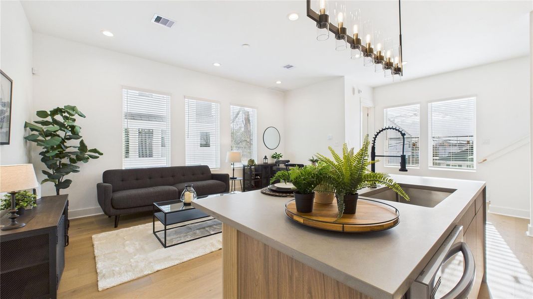 The heart of the second-floor open-concept living, dining, and kitchen, this spacious kitchen island features sleek modern finishes, including a one-sided cascade quartz countertop, a farmhouse sink, and stylish pendant lighting, with a built-in seating area perfect for casual breakfasts or chatting with family and friends.