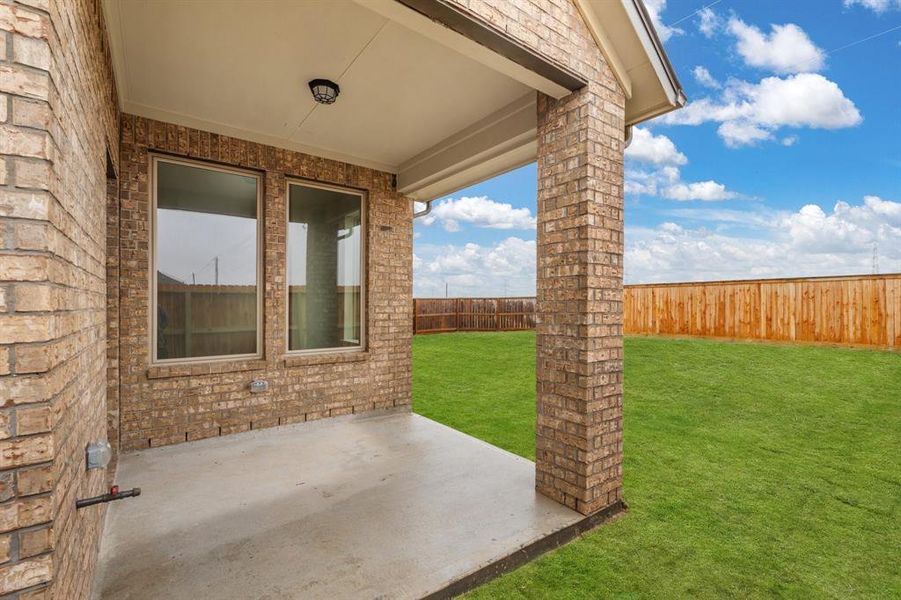 The covered patio is generously sized, providing ample space for various outdoor activities.