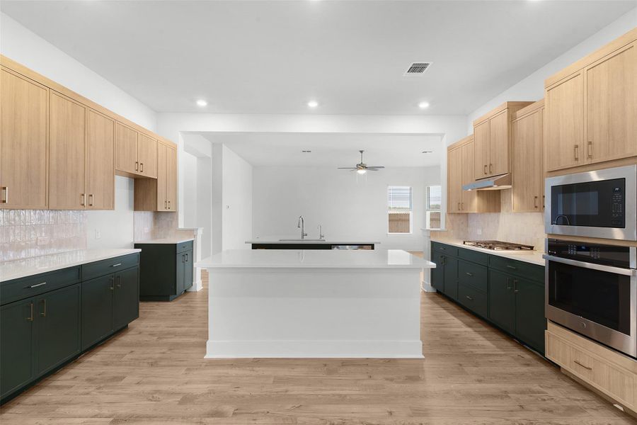 A pristine kitchen features an expansive island and sophisticated appliances, perfect for culinary endeavors.