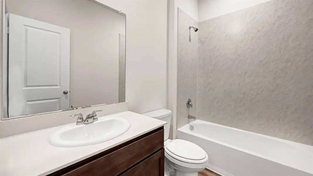 Full bathroom featuring a single vanity with an integrated sink, polished chrome faucet, and a large wall-mounted mirror