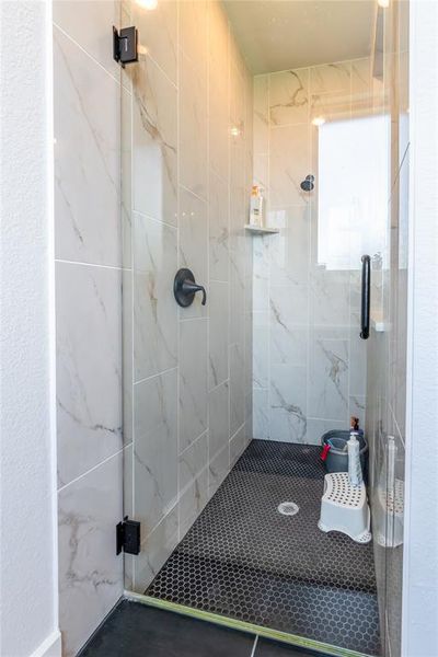Bathroom with a marble finish shower