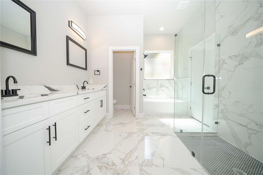 Full bath with light marble finish flooring, a bath, a marble finish shower, double vanity, and recessed lighting Full bath with light marble finish flooring, a bath, a marble finish shower, double vanity, and recessed lighting